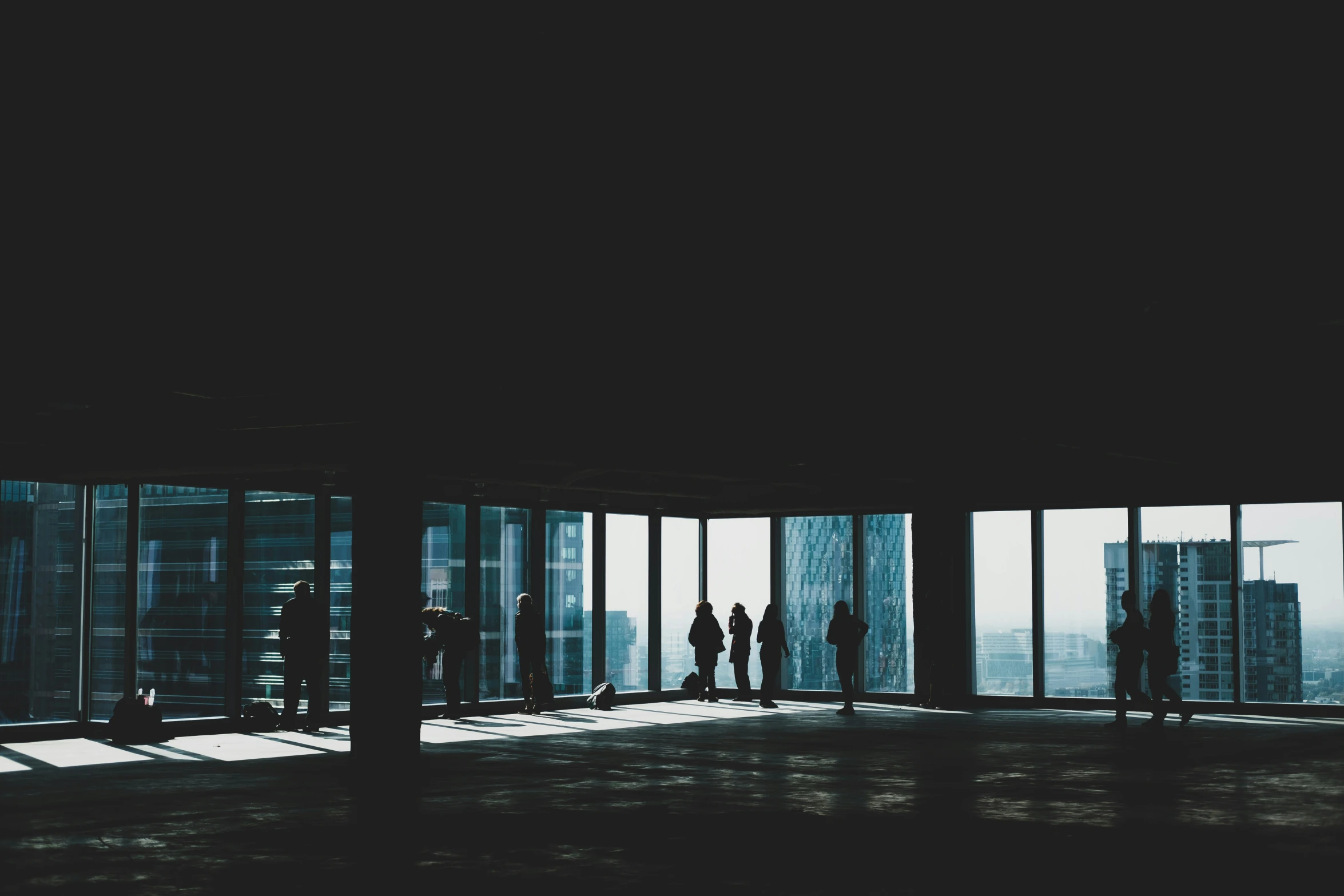 a group of people standing inside a window covered room