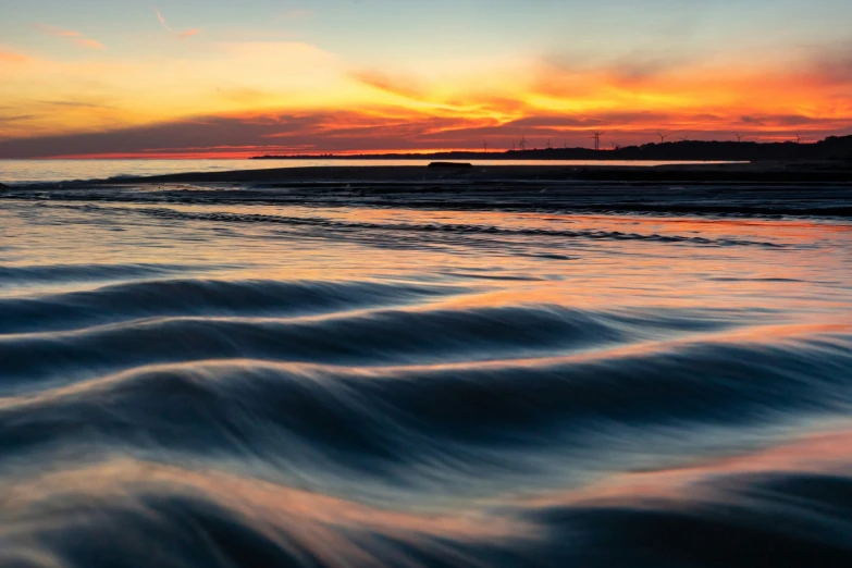 the view from a beach at sunset with waves and sunset