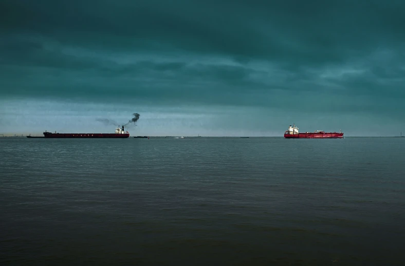 a big ship and a cargo boat sailing across a big body of water