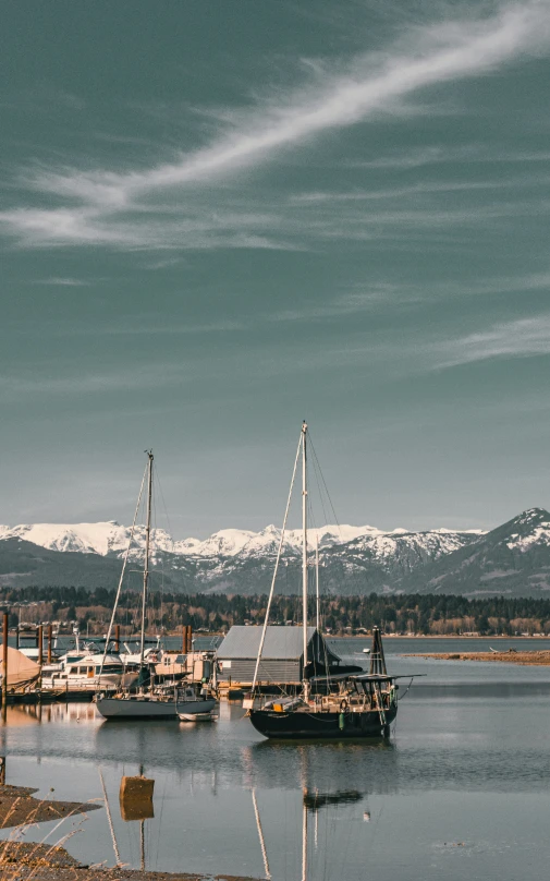 many boats docked in a harbor next to mountains