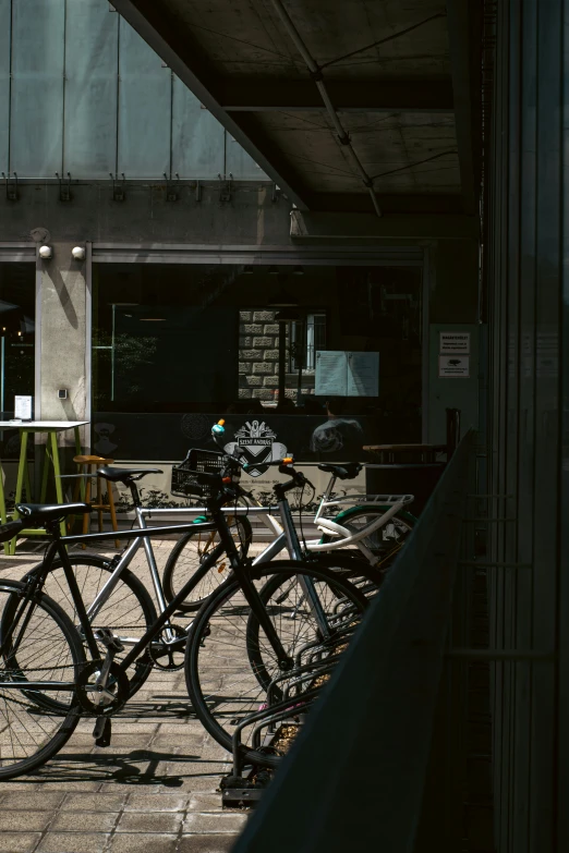 bicycles parked outside of an office building with lights