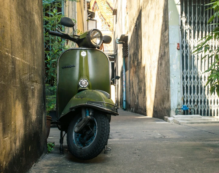 a scooter parked next to a wall near another building