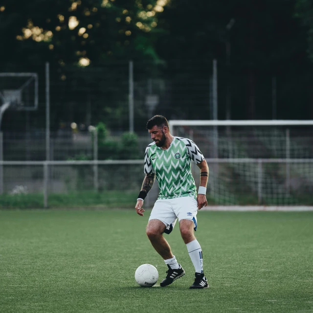 man on field with soccer ball during daytime