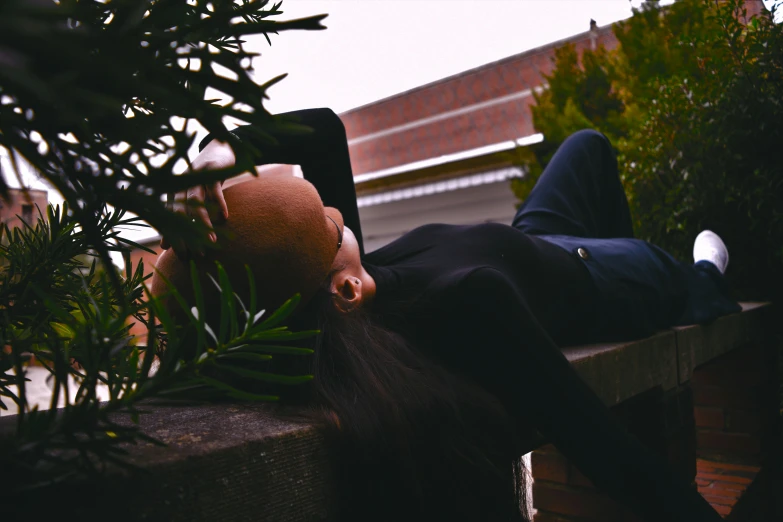 a man wearing a suit and head scarf laying on a bench