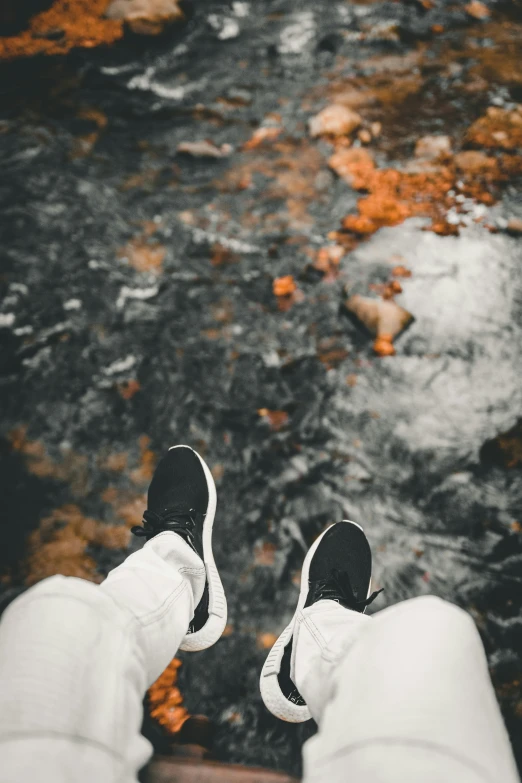 a person standing on a street, wearing tennis shoes