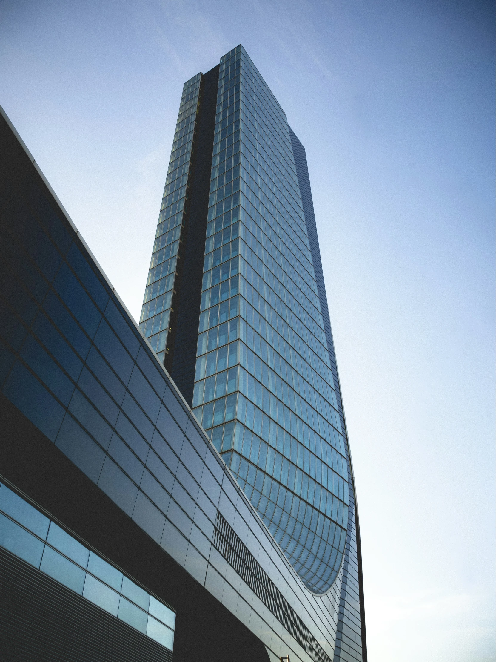 the sky and side of a tall glass building