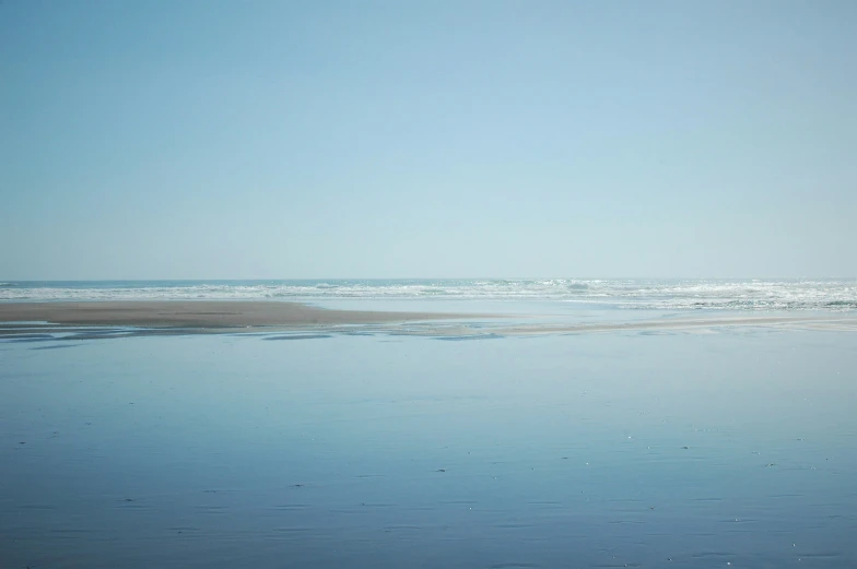 a surfer standing on the beach in the ocean