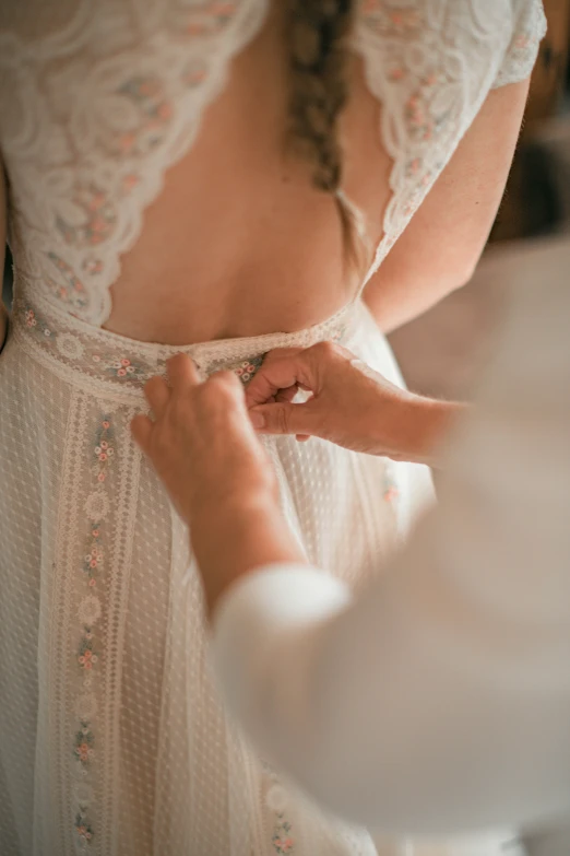 a woman tying a dress on another woman