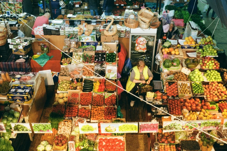 a woman stands by a fruit stand selling produce