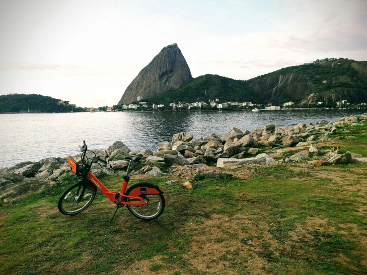 a bike leaning against some rocks on the shore