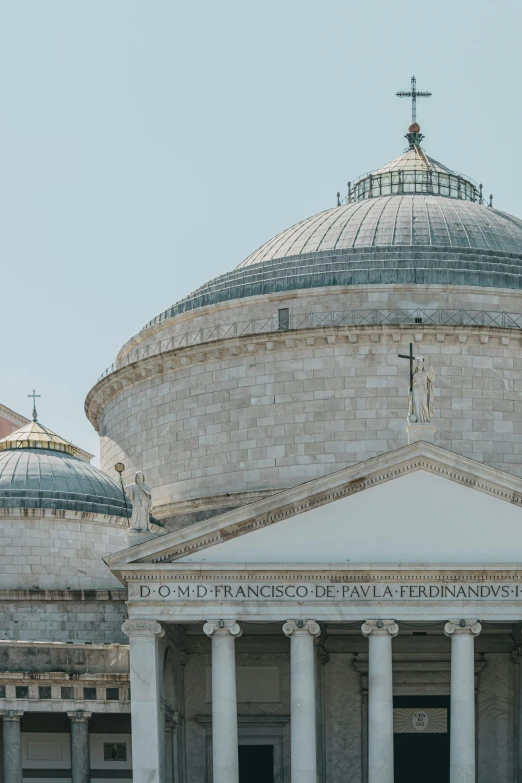 a building has an ornate dome, some columns, and a cross