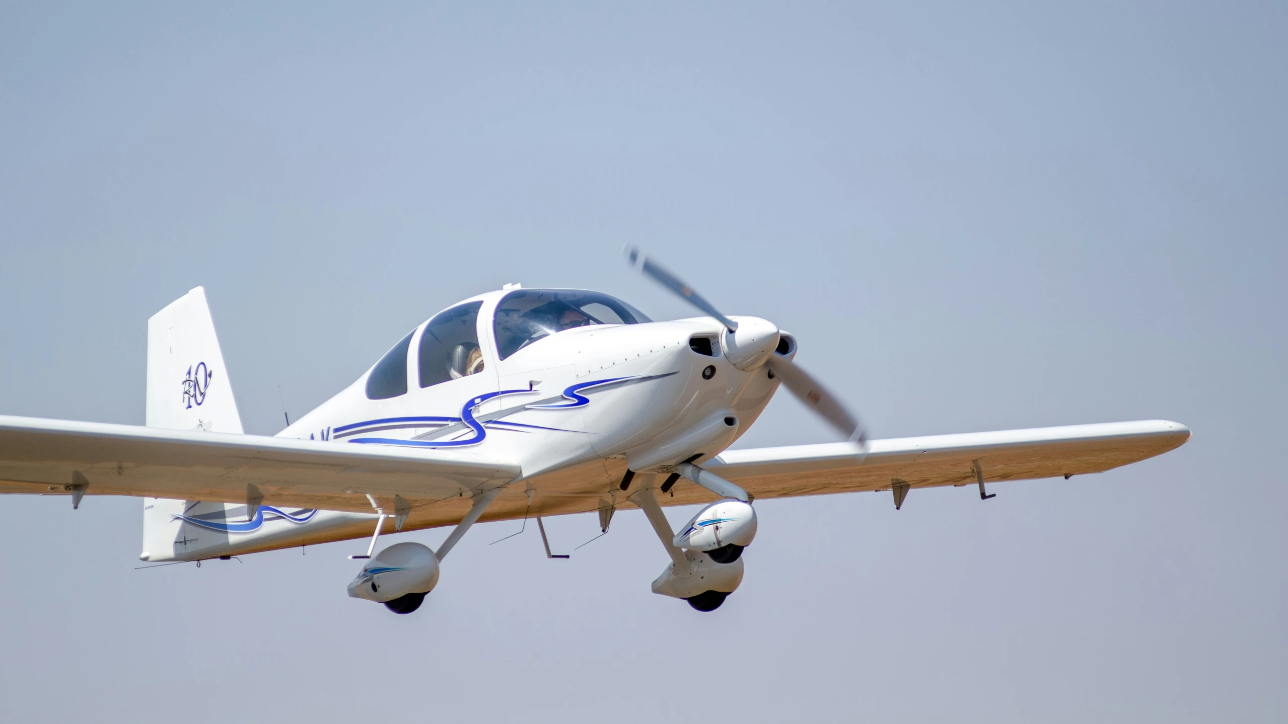 an airplane flying in the sky with a light landing gear down