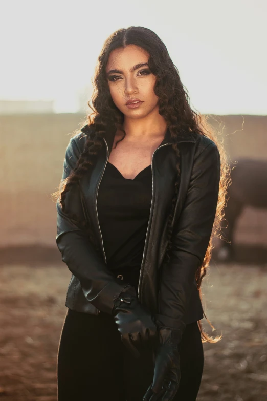 a beautiful woman in a leather jacket and gloves posing