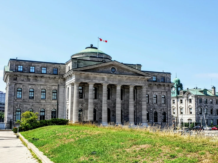 a green lawn with a building and two spires on top