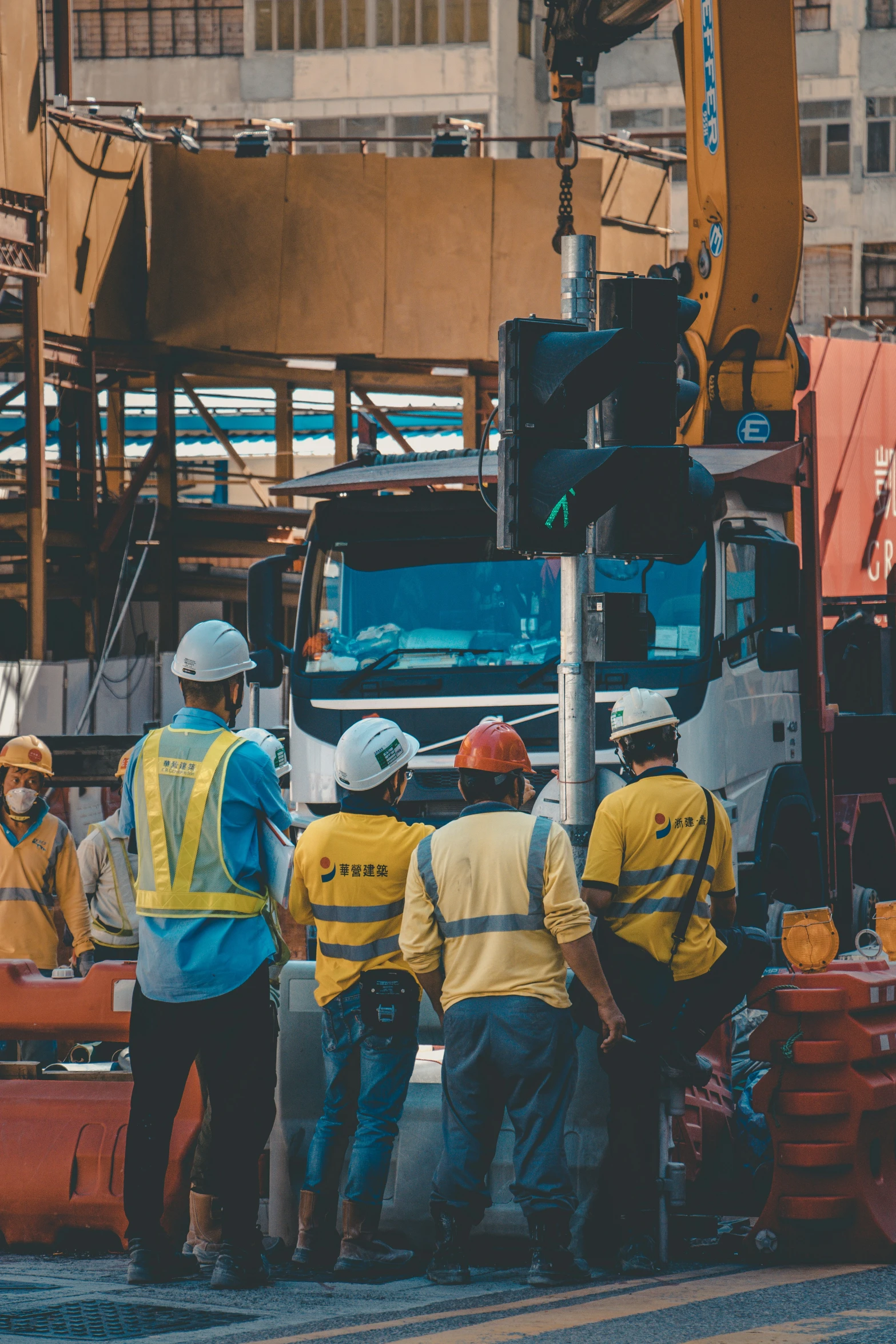 a group of workers stand around a large truck