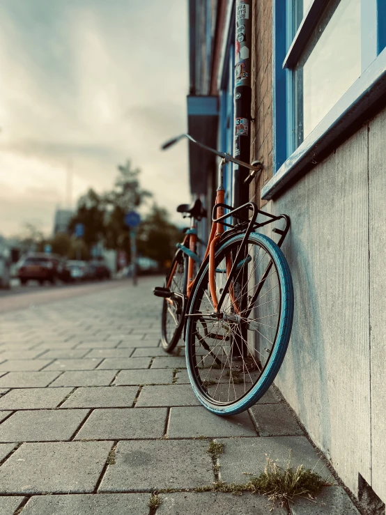 a bike  to a wall on a sidewalk
