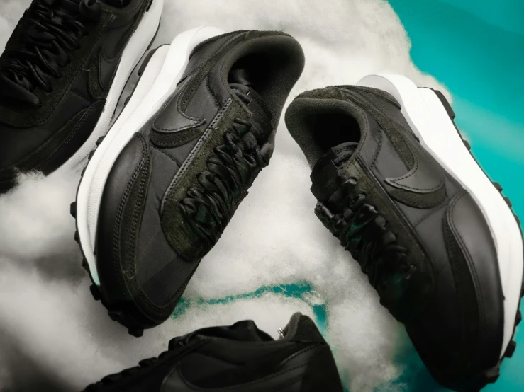 a group of black nike shoes on a cloud of snow