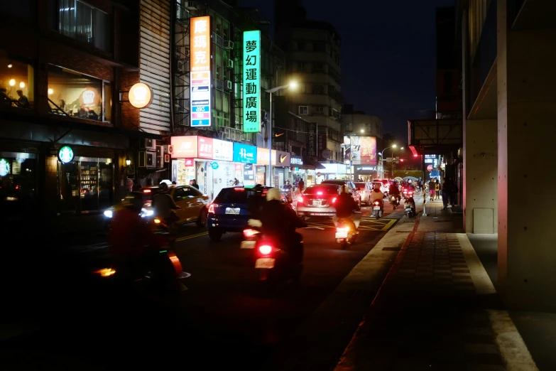 a nighttime scene of the busy road with many car and motorcycle traffic