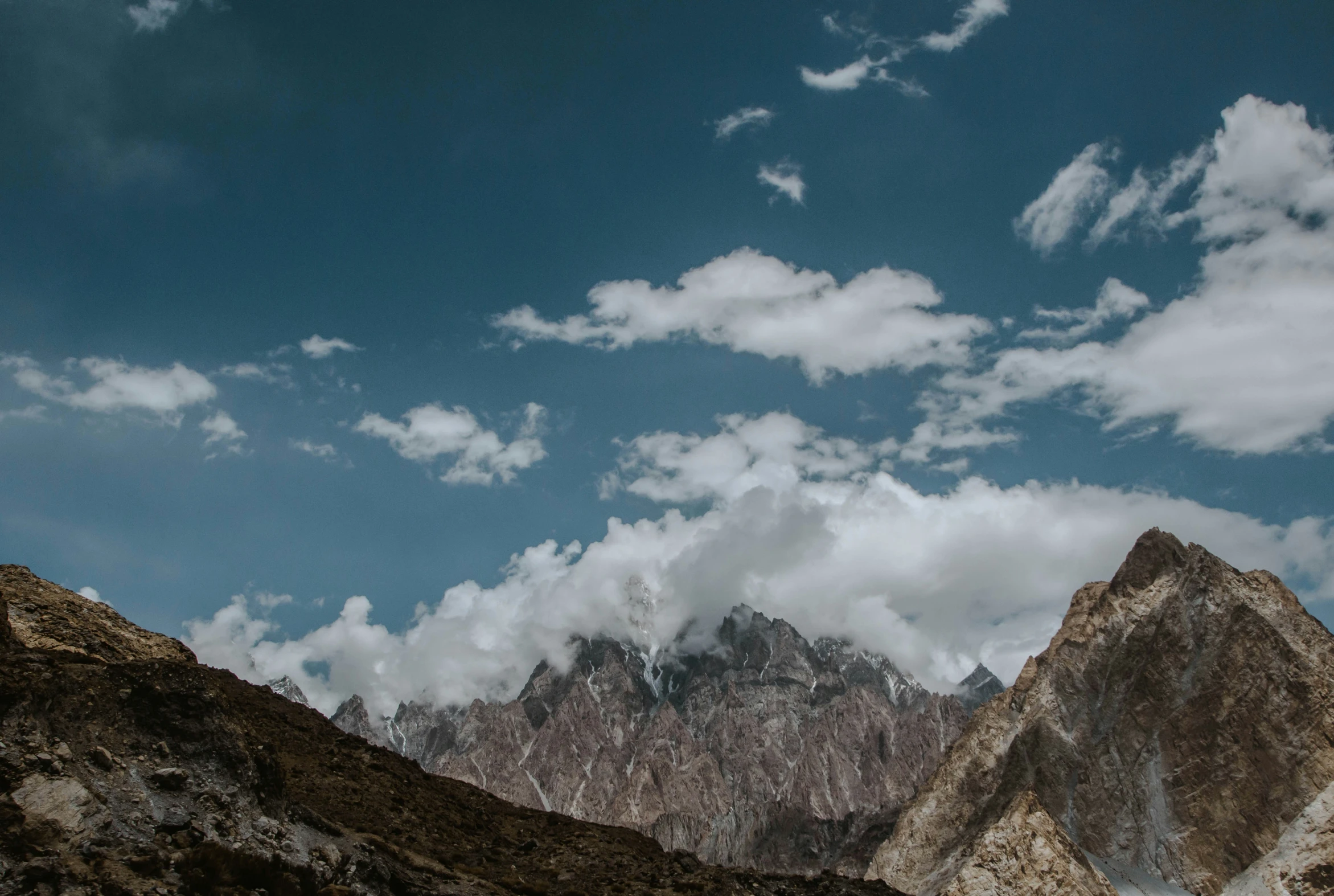 mountain peaks under a cloudy sky with lots of clouds