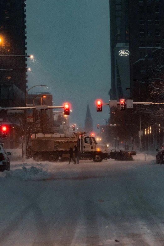 cars driving through the snow at night and stop lights