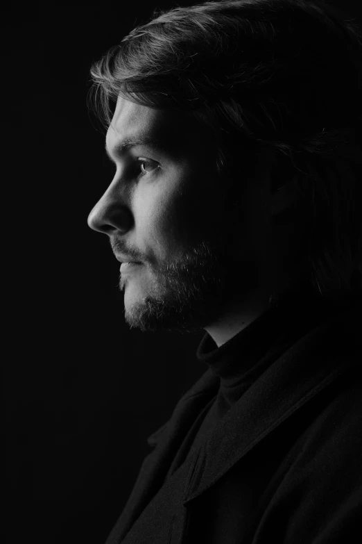 a man is looking off into the distance in black and white