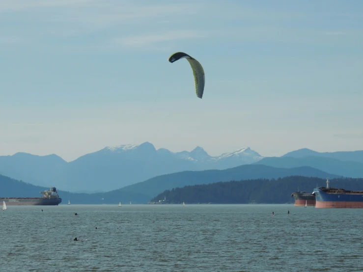 a wind surfer in a body of water flying a kite