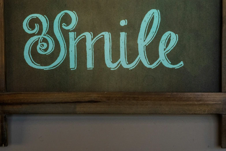 the words smile are etched on a chalkboard