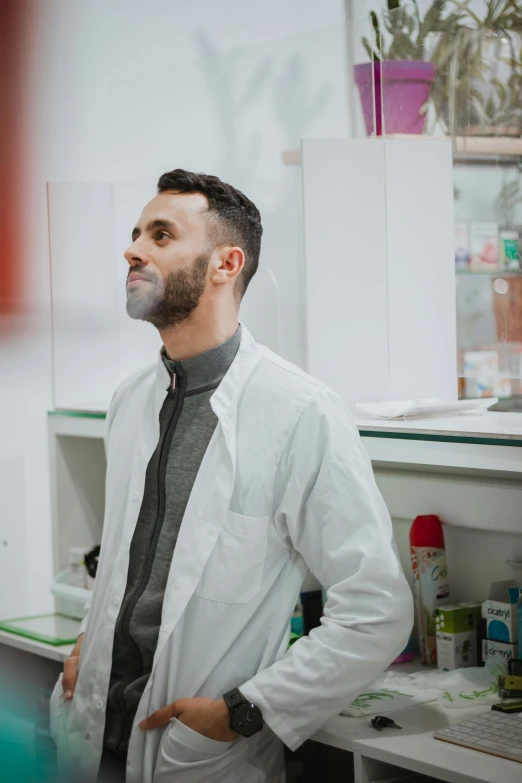 a man in white coat standing in a lab