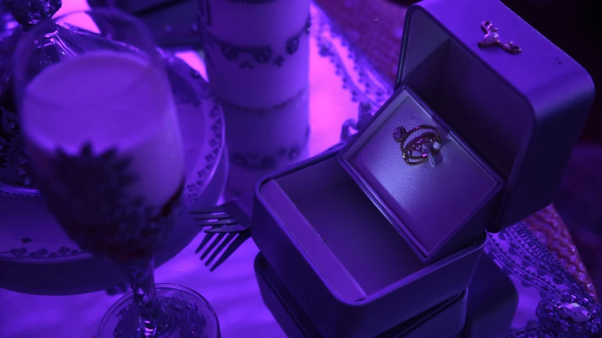 a purple table with some cups and some gold jewelry