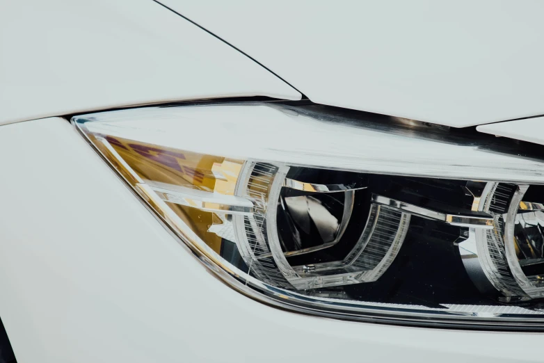 a close up of the front lights and chrome trim on a white car