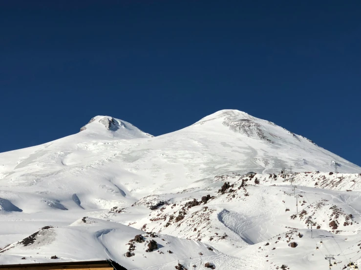 the top of the snow - capped mountain against a blue sky