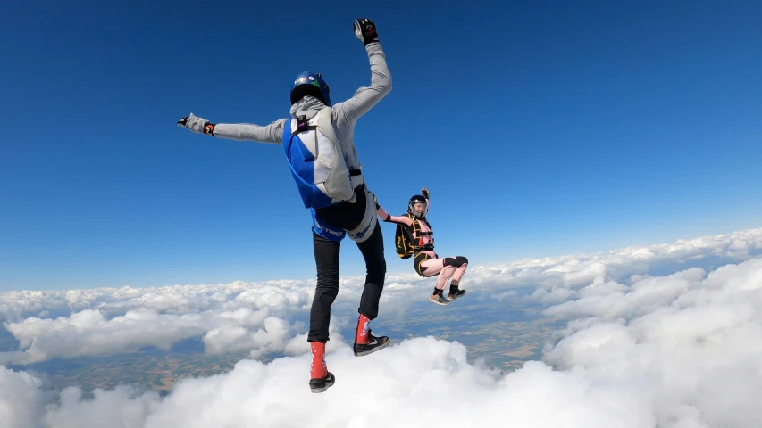 two people parachuting above the clouds on skis