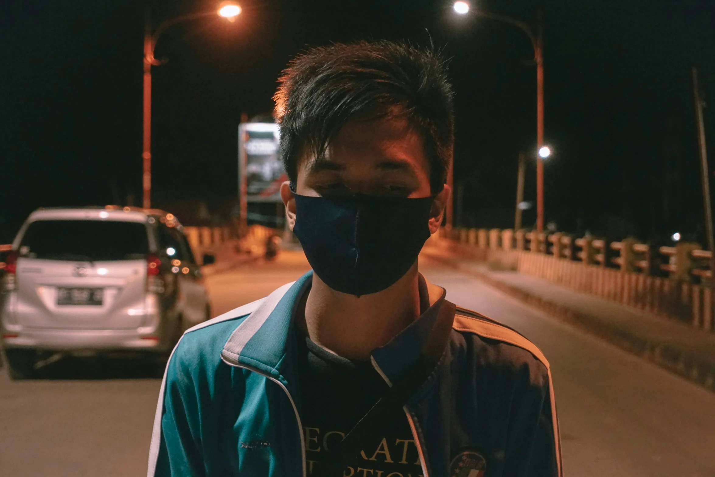 a guy wearing a black mask on a city street