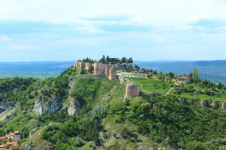 a small castle sits on top of the mountain