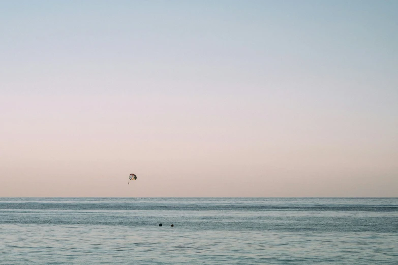 an ocean and some birds flying in the sky