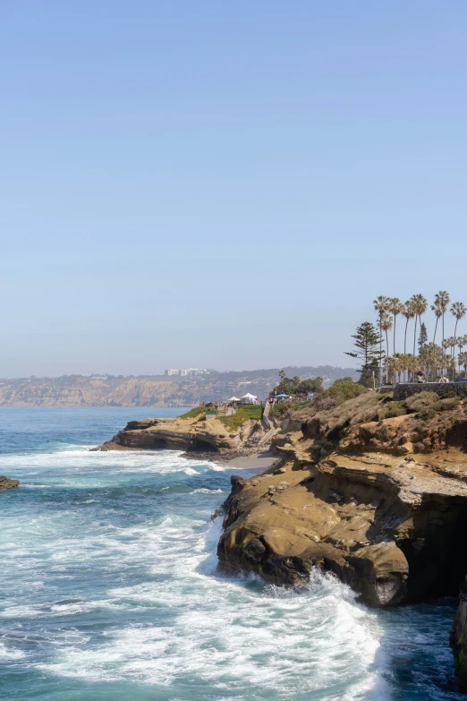 the surf is coming toward the rocky shore