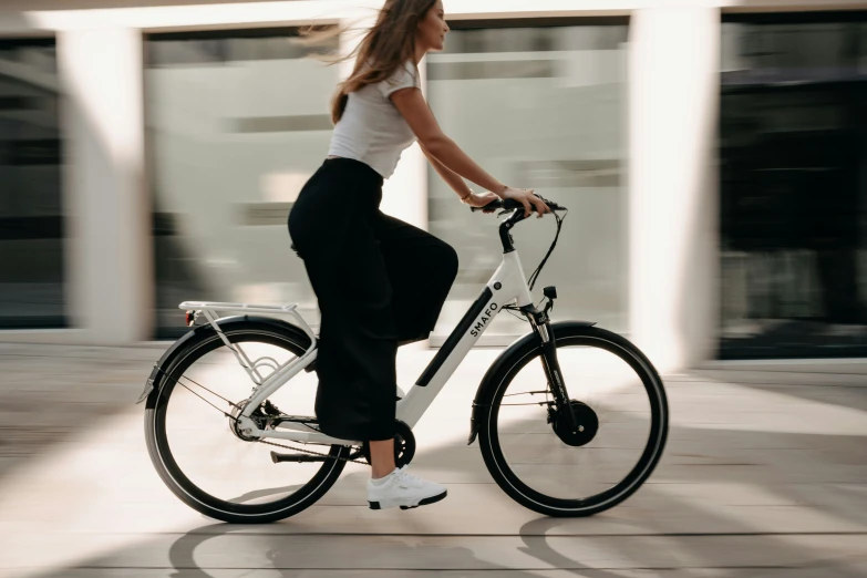 a woman is riding on a bike down a sidewalk