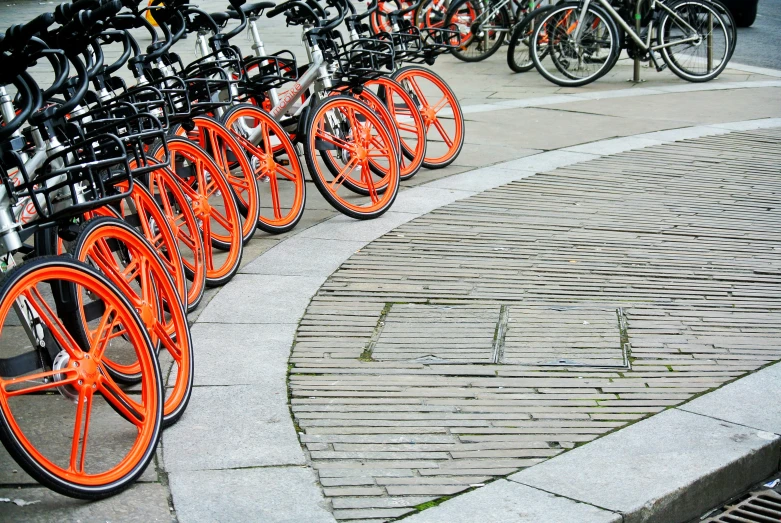 bikes are lined up along the sidewalk in an area