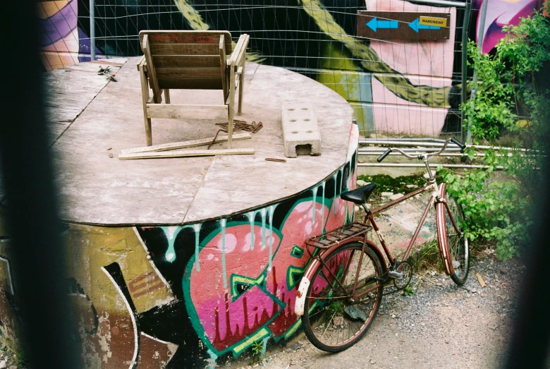 a bicycle that is sitting outside next to a chair