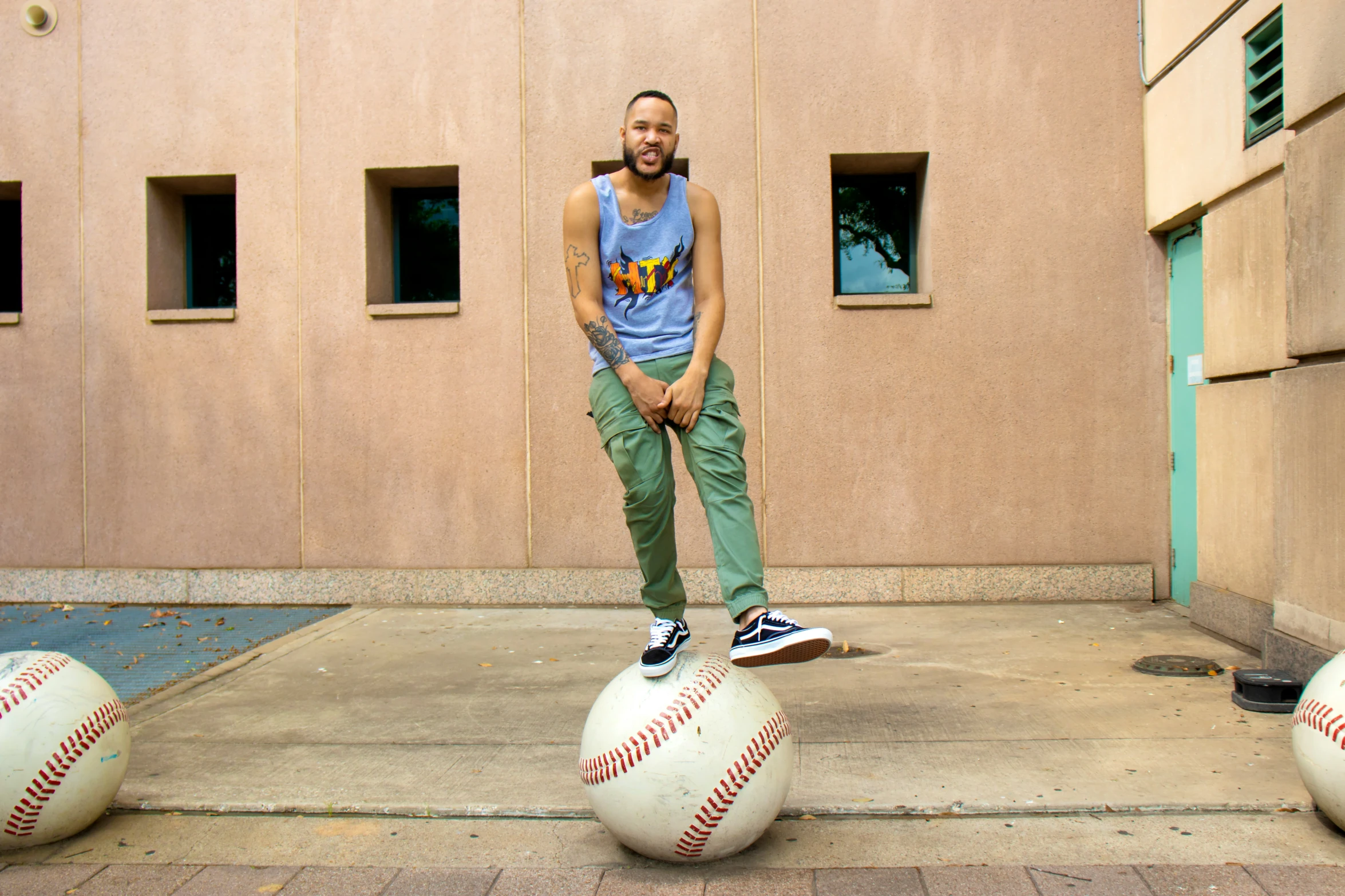 man standing on top of three baseball balls