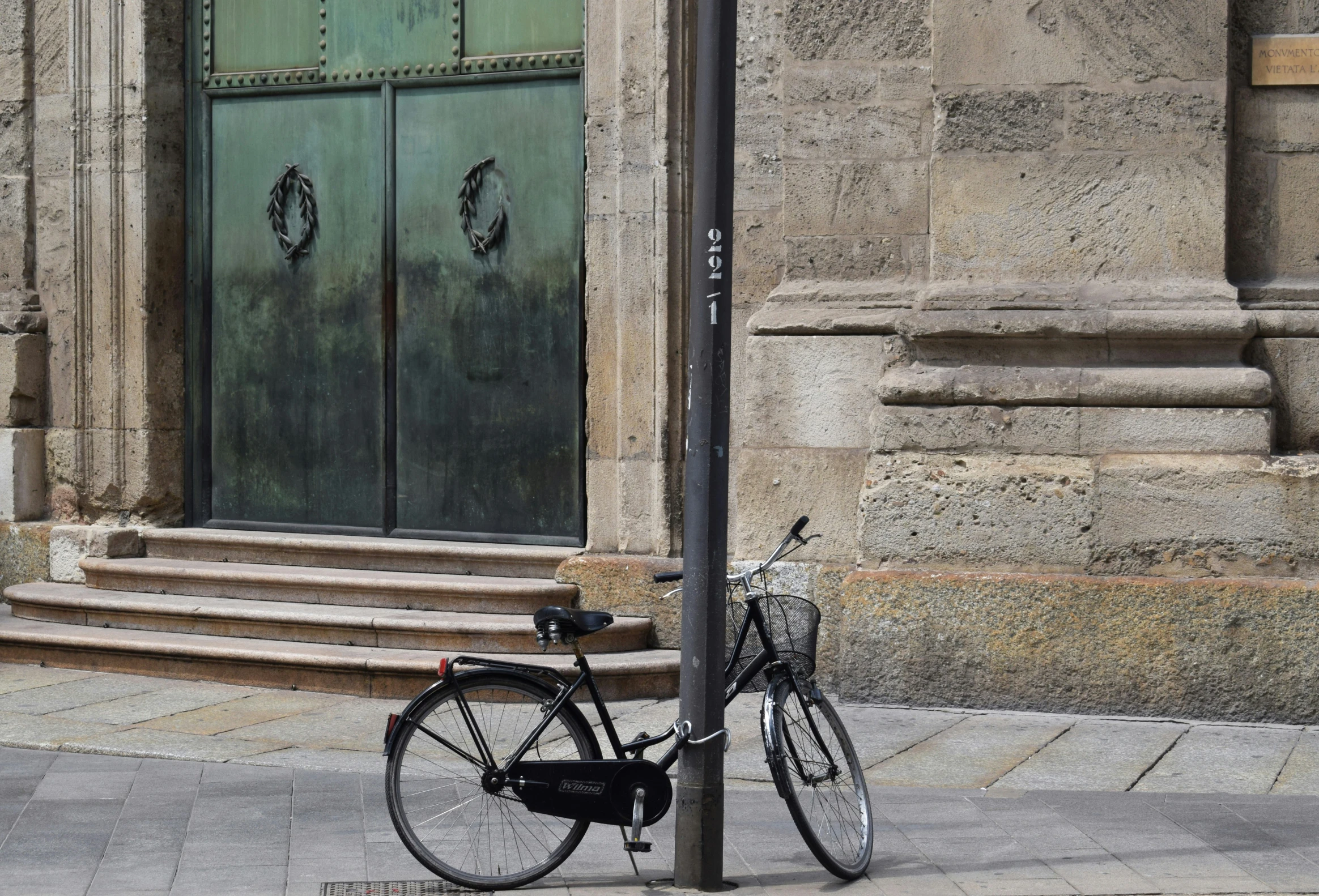 a bicycle is parked next to a street pole