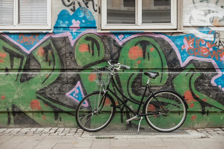 a black bicycle is parked near the wall