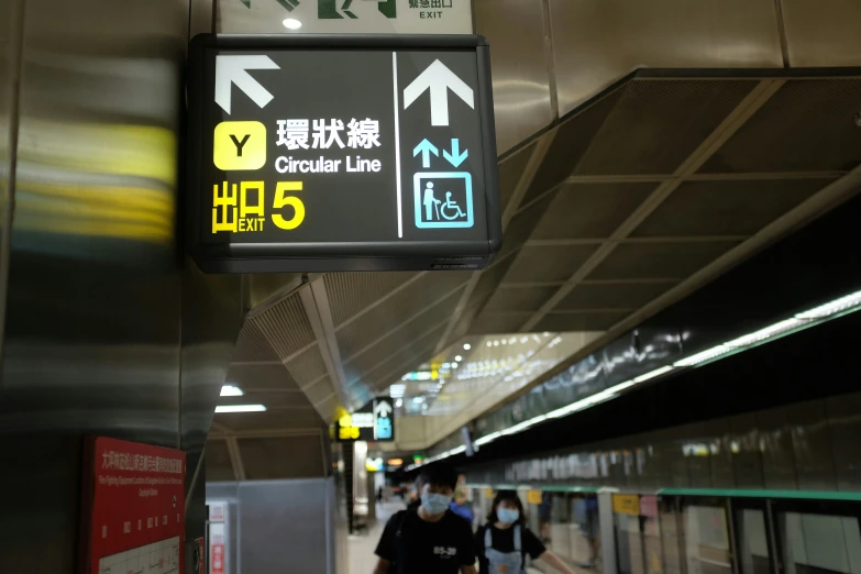 a sign in a subway station that points the way to various things