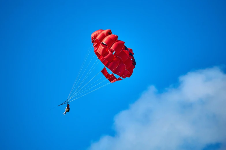 a person is parasailing in the blue sky