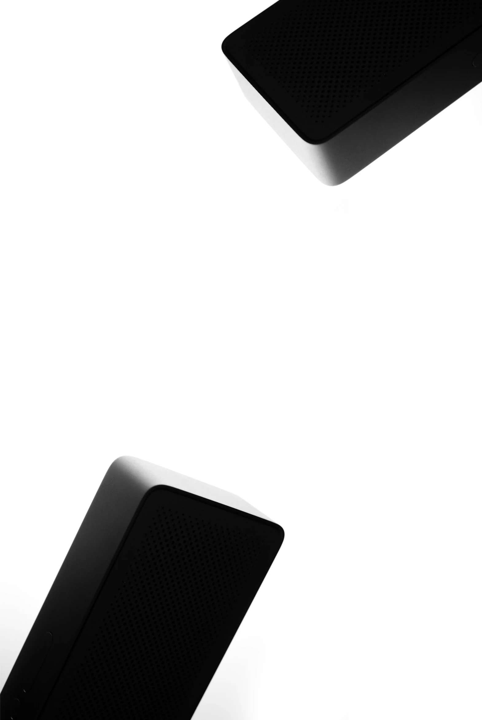 two black speakers on white background with light in them