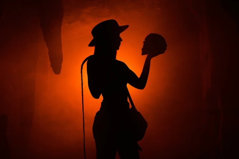 silhouette of woman holding a lit candle in her hand