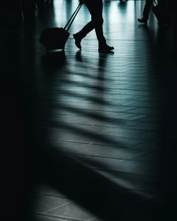 a person pulling a suitcase and pulling luggage in an airport