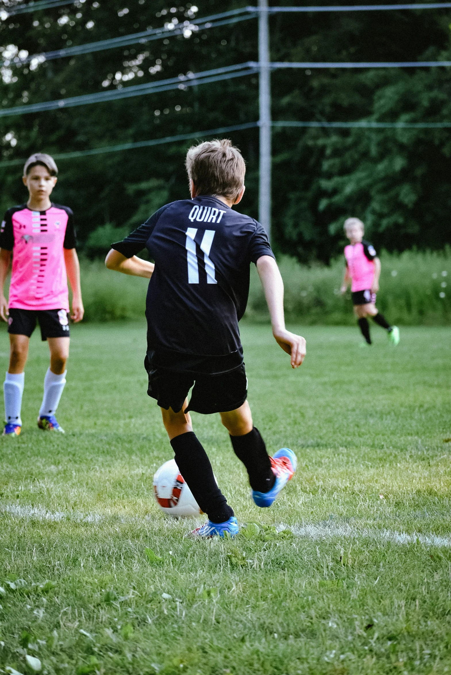 a group of young people standing on top of a field playing soccer