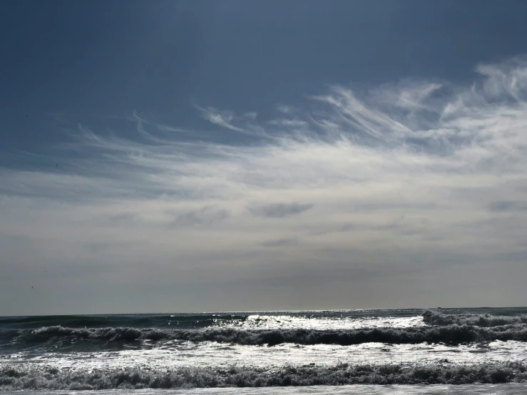 an ocean filled with waves next to a tall building