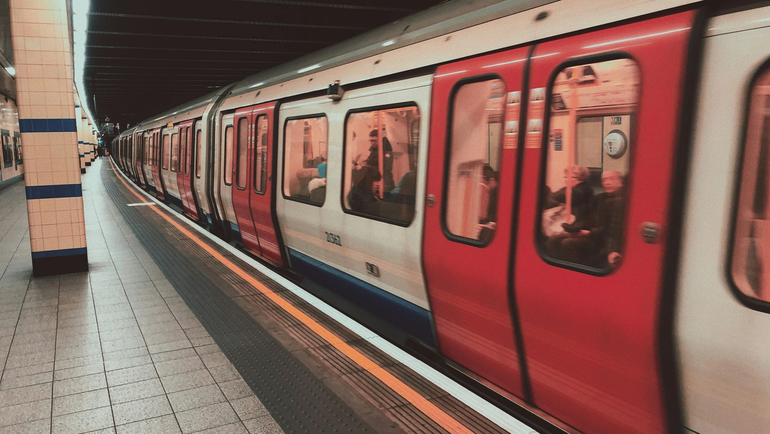 two people in the middle of a platform at a train station